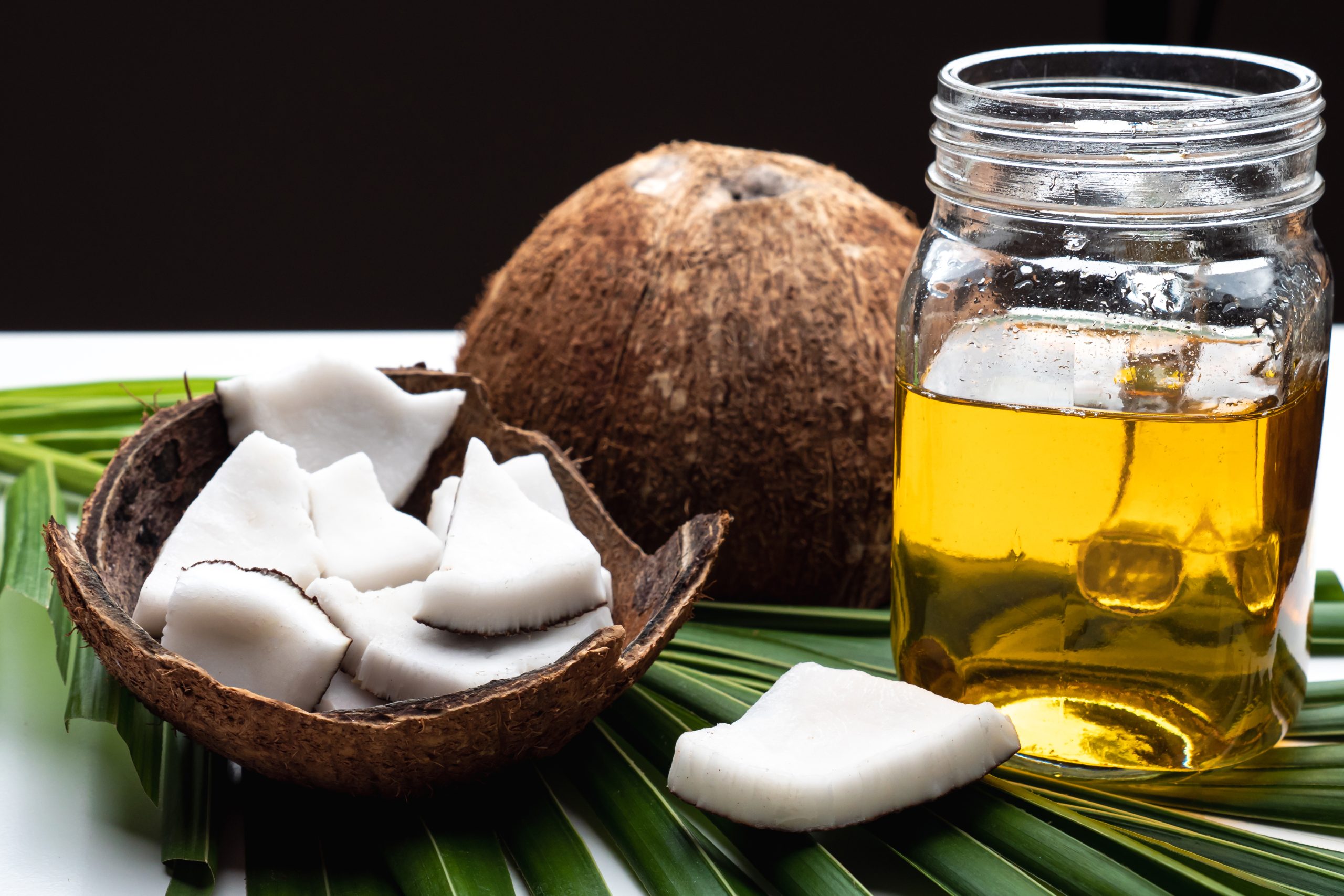 coconut-meat-and-coconut-oil-in-glass-bottle-on-co-2023-11-27-04-59-38-utc-scaled.jpg
